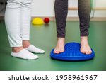Patient with flat feet standing on a spiky massage pad