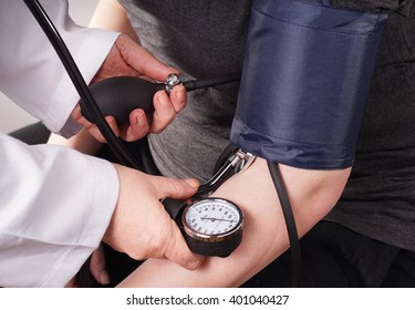 Patient Gets Blood Pressure Check Up By The Doctor