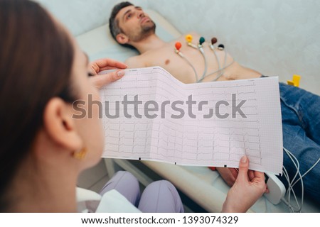 patient getting heart rate monitored with electrocardiogram equipment. cardiogram test, Close-up Of Ecg Report