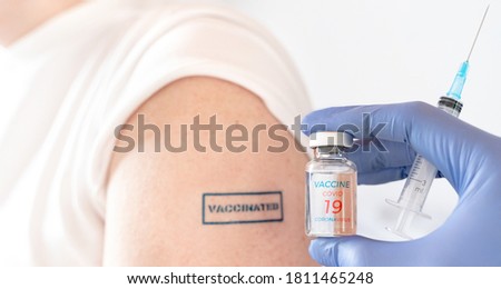 Patient hand with blue stamp vaccinated.Doctor's syringe,vial with vaccine for covid-19 coronavirus,flu,infectious diseases.Injection after clinical trials for human,child,adult, senior.Medicine,drug.