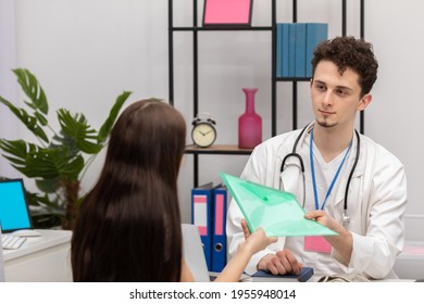 A Patient Hands The Doctor A Folder With All The Test Results. Primary Care Physician. Doctor's Office