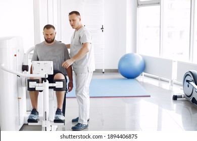 Patient has a rehabilitation in physiotherapy clinic. Doctor in a uniform.