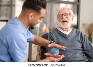 Patient having his hand massaged with a spiky massage ball - Shutterstock ID 2154952883