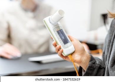 Patient holding spirometer, medical instrument for measuring breathing movemnts, close-up