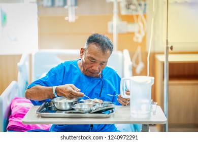 Patient Hospital Health Concept, Asian Old Man Patient Eating Food, Drug In Emergency Room Of Hospital. Old Man Holding Spoon  On Bed For Checking By Doctor And Nurse Treatment From Saline Medicine 