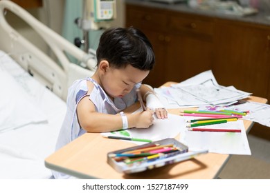 The patient kid is painting the paper with a color pencil in the hospital. - Powered by Shutterstock