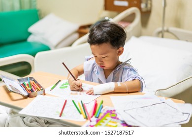 The patient kid is painting the paper with a color pencil in the hospital. - Powered by Shutterstock