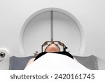 The patient lies in front of the device for the treatment of cancer with a gamma knife. She has a metal clip cap on his head. Gamma Knife stereotactic radiosurgery.