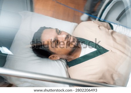 Patient lying inside a hyperbaric chamber, focusing on health, wellness, and recovery through advanced medical therapy