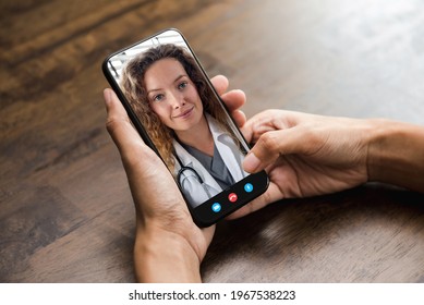 Patient making video call with doctor online via mobile phone, home medical consulation service and telehealth concepts - Shutterstock ID 1967538223