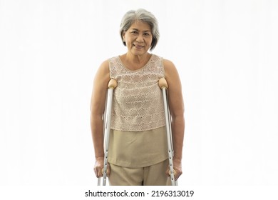 Patient Older Woman And Crutches. Elderly Asian Woman Standing With Crutches. Senior Woman Using Crutches. Health Care Concept