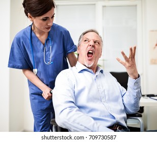 Patient On A Wheelchair Getting Angry With Nurse