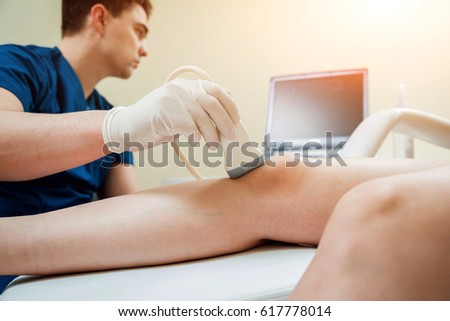 Patient with orthopedist doctor in his office. Knee sonography.