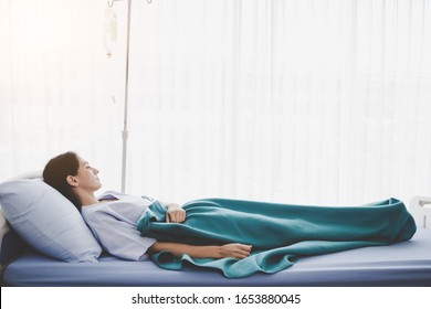 Patient person sleep on patient bed in hospital room. Sick woman get high fever. Illness girl get Surveillance or quarantine symptoms in separate patient room. She get tired, weak. Patient get cancer
