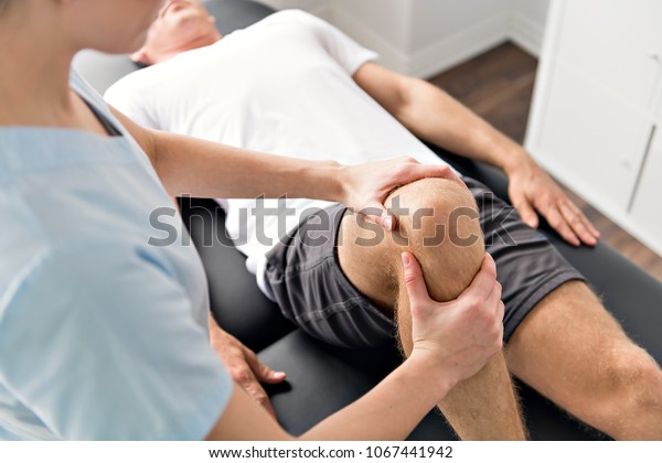 Patient at the physiotherapy doing physical\
exercises with his\
therapist