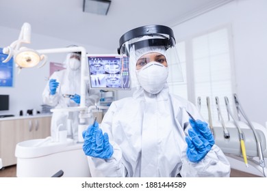 Patient Pov Of Dentist Team Preparing For Teeth Treatment In Dental Office. Stomatolog Wearing Safety Gear Against Coronavirus During Heatlhcare Check Of Patient.