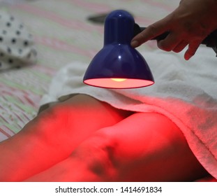 Patient receiving color therapy, chromotherapy on body treatment with red light. Colorful lights stimulating the psyche.