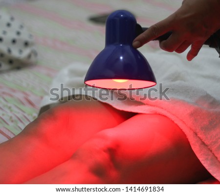 Patient receiving color therapy, chromotherapy on body treatment with red light. Colorful lights stimulating the psyche.