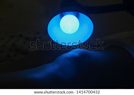 Patient receiving color therapy, chromotherapy on body treatment with blue light. Colorful lights stimulating the psyche.