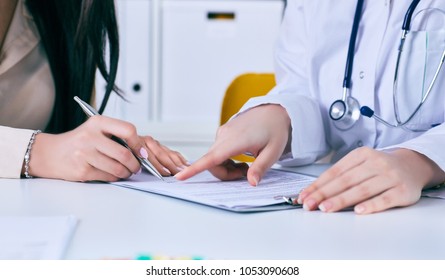 Patient Signing Medical Contract. Female Doctor Explains How To Fill Medical Form.