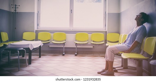 Patient sitting in a waiting room of a hospital - Powered by Shutterstock