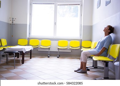 Patient sitting in a waiting room of a hospital - Powered by Shutterstock