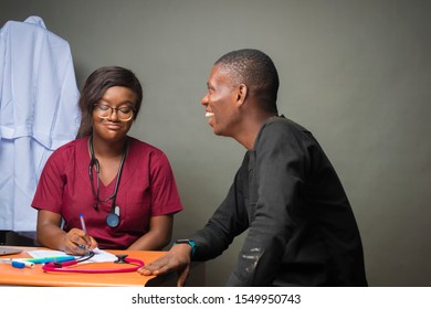 Patient Smiling With A Young Black Female African Doctor During A Medical Check Up