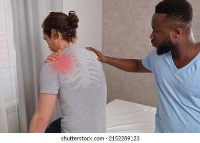 Patient Suffering From Back And Shoulder Pain During Medical Exam. Chiropractic, Physiotherapy Concept.