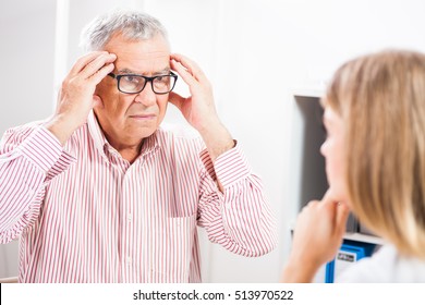 Patient is telling doctor about his health problems. He is having headache. - Shutterstock ID 513970522