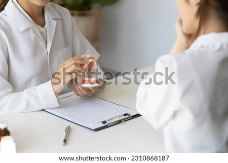 Patient with a toothache sees a dentist in a dental clinic at a hospital examination room. The doctor gives advice on maintaining oral health.