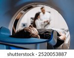 A patient undergoes an MRI or CT scan as doctors review images in a modern diagnostic center. This scene highlights the synergy between advanced technology and healthcare for accurate diagnoses.