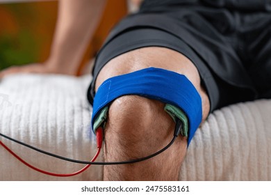 A patient undergoing knee therapy with electrotherapy treatment for pain relief and rehabilitation. - Powered by Shutterstock