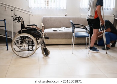 Patient undergoing physical therapy in a rehabilitation center, using crutches. The image captures mobility aids, including a wheelchair, conveying recovery and support themes. - Powered by Shutterstock