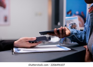 Patient using credit card to pay checkup visit with specialist, paying for consultation and treatment at facility reception desk. Making payment after having examination appointment. Close up.