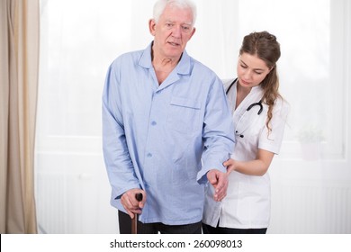 Patient Using Walking Stick Assisted By Doctor