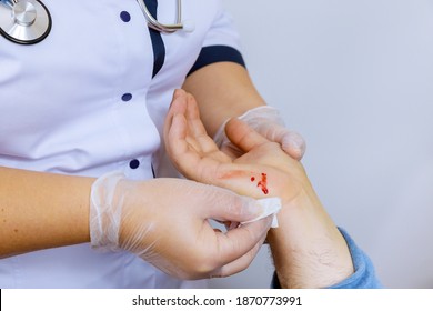 Patient Visiting Hand Injury Doctor Wipes The Blood Cleaning A Wound