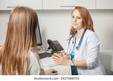 Patient visiting his doctor at hospital. Doctor woman at work in hospital excited and happy of consulting female patient. Physician controls medication history records and exam results. Medicine. - Powered by Shutterstock