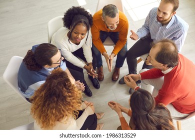 Patients talking in group therapy feeling connected, safe and supported. Diverse people trying to understand each other in friendly positive atmosphere of psychotherapy session. High angle, from above - Powered by Shutterstock