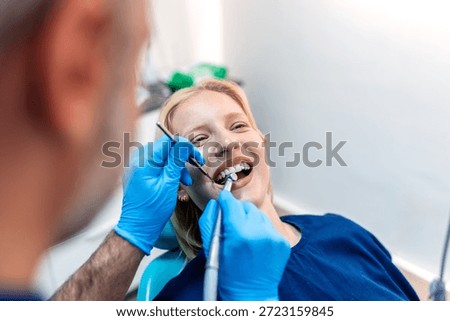 Patient's teeth shade with samples for bleaching treatment. Viewed oral hygiene. Woman at the dentist. Woman in the dental chair dental treatment during surgery.