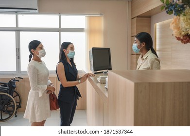 Patients Wearing Face Mask Contact For Treatment Sickness With Receptionist At Counter Reception In Hospital