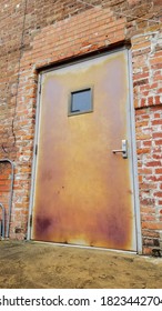 Patinaed Back Alley Door With Small Square Window