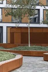 Patio Detail In A Residential Building In A European City. Modern Blocks Of Flats. Courtyard With Plants And Lighting. Rust Metal Finish, Corten. Underground Garage
