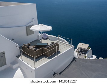 Patio Furniture On Deck Above Blue Ocean In Santorini