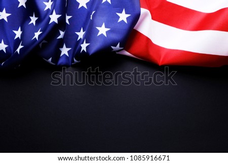 Patriotic composition w/ ruffled American flag on black background. United States of America stars & stripes symbol with copy spase for text. 4th of july Independence day concept. Background, close up