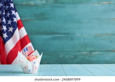 Patriotic cupcake 4th july with american flag. Delicious cupcake with cream cheese and blue and red toping on old blue wooden background. Dessert food for American Independence Day celebration. - Powered by Shutterstock
