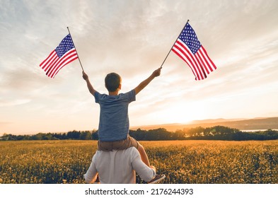 A Patriotic Family Waving American USA Flags On Sunset