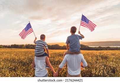 A Patriotic Family Waving American USA Flags On Sunset