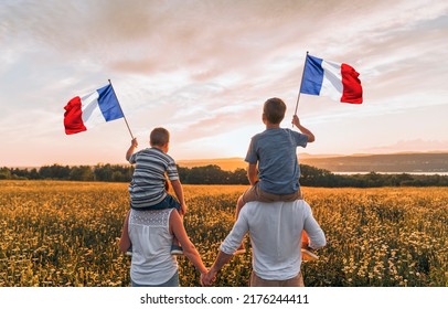 A Patriotic Family Waving France Flags On Sunset