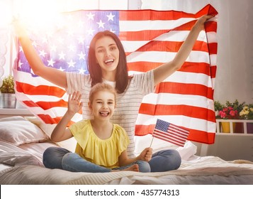 Patriotic Holiday. Happy Family, Mother And Her Daughter Child Girl With American Flag At Home. USA Celebrate 4th Of July.