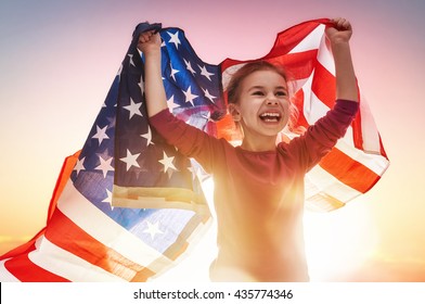 Patriotic holiday. Happy kid, cute little child girl with American flag. USA celebrate 4th of July.